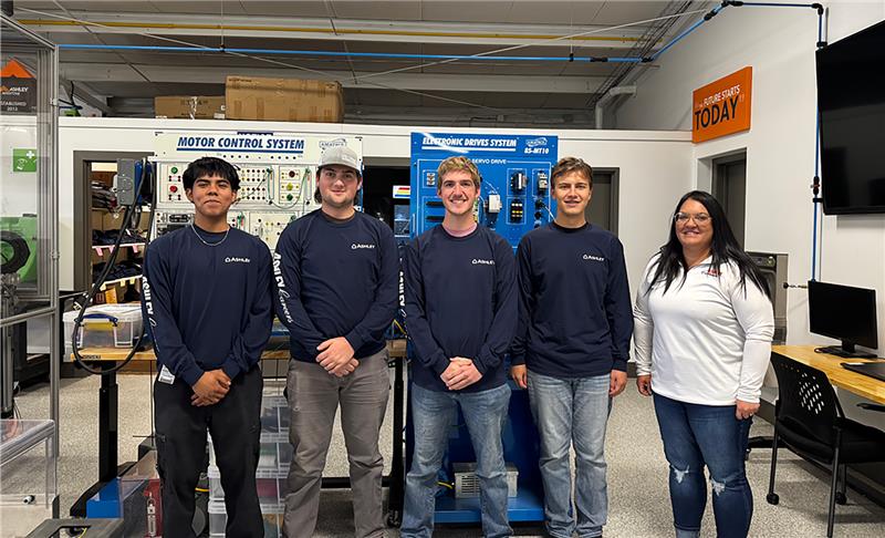 A group of 5 people are smiling at the camera.