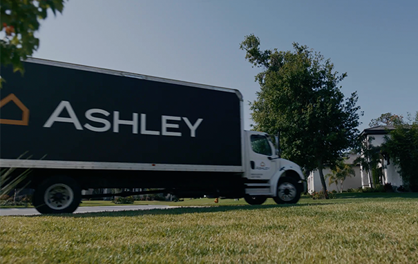 Ashley box truck parked in a lawn of a home.