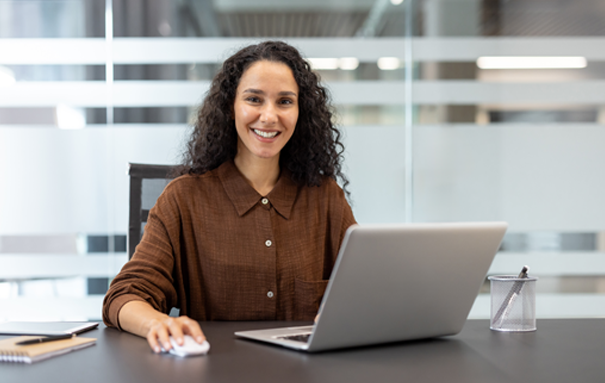 Female Ashley employee smiling with a computer in front of her.