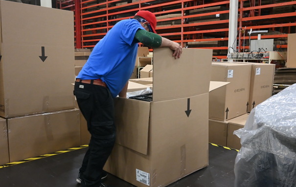 Ashley male associate closing a carton box