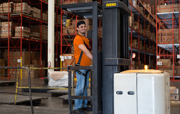 Ashley male associate in a forklift smiling at the camera