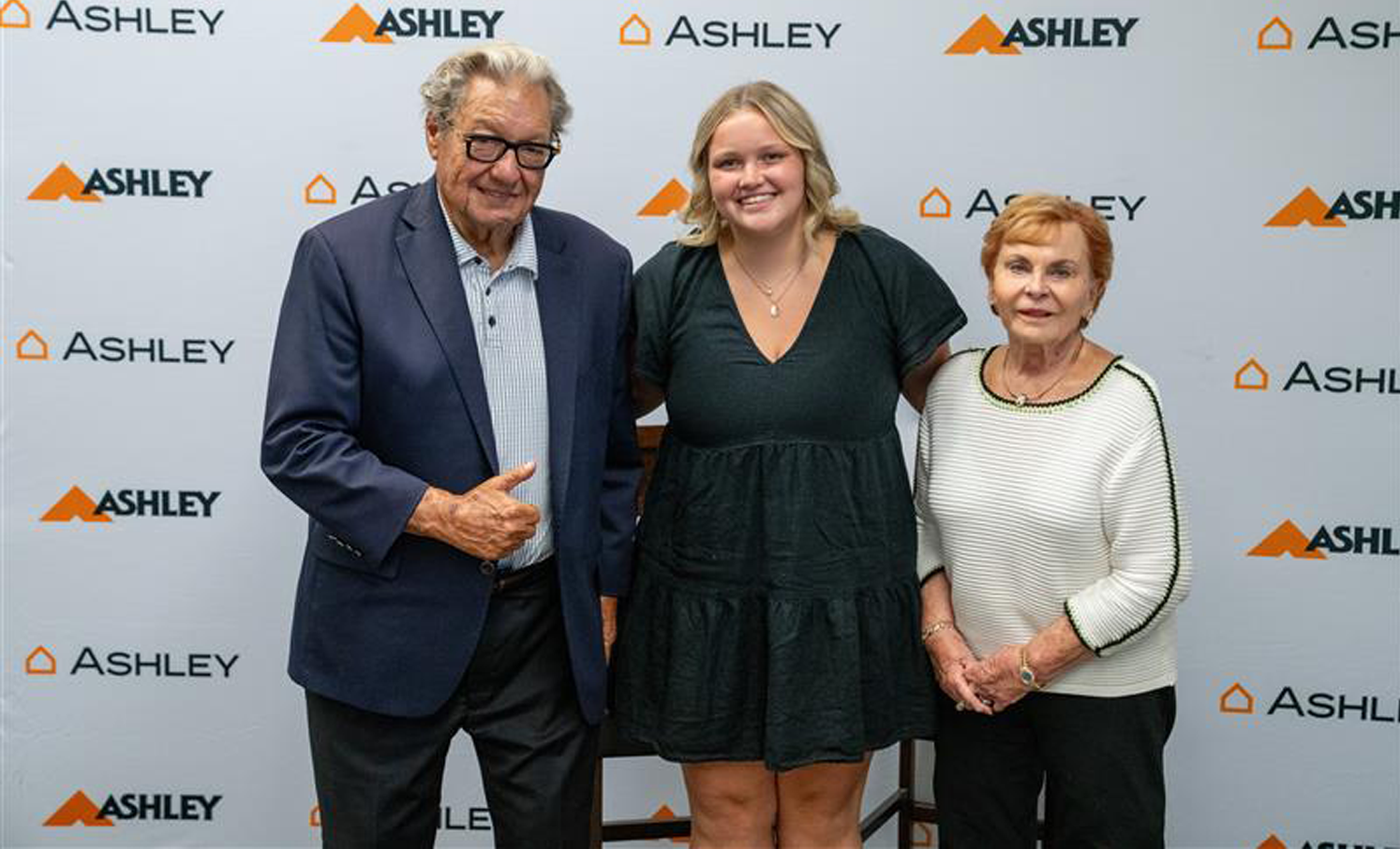 Ron Wanek and his wife are between a young lady.